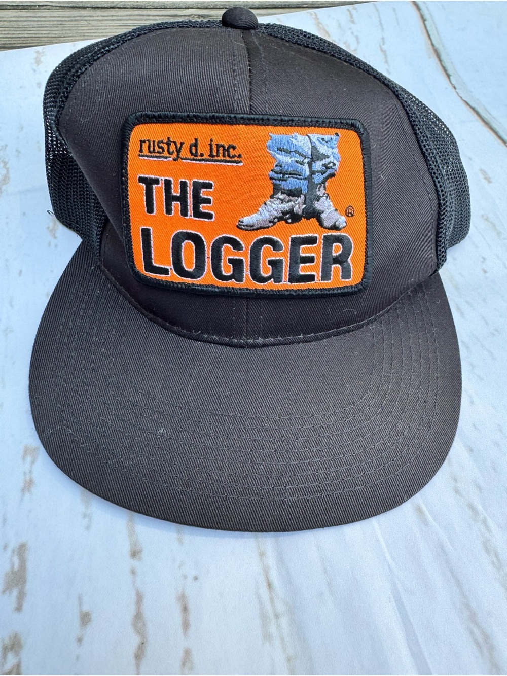 The Logger Black Trucker Hat with Orange Patch